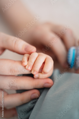 Newborn baby hand holding parent finger close up