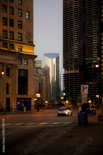 Wallpaper Mural View of a Car Driving Down a Chicago Street at Sunrise with Tall Buildings Surrounding it Torontodigital.ca