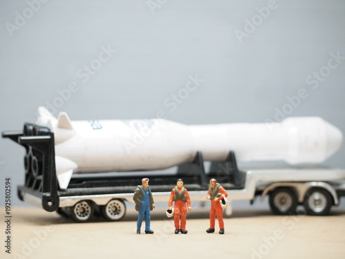 Mini toy of action figure at bullet missile with blurred background. Miniature diorama photography concept design. Minifigure of military crew with balistic rudal weapon. Base Umited States of America