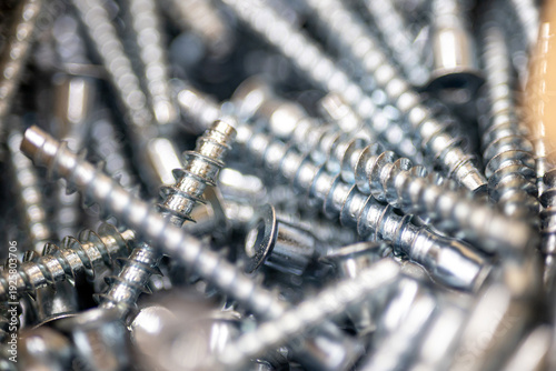 Pile of metal screws and bolts for construction and woodworking industry professional hardware