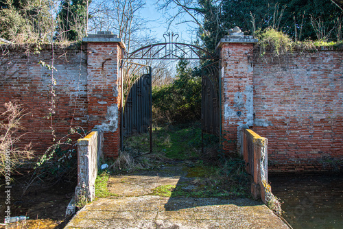 L'ingresso del forte abbandonato di Ca' Roman, isola della laguna di Venezia, con il ponte che attraversa il fossato e il cancello aperto