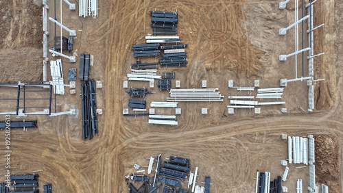 An outdoor warehouse of pipes (plastic and steel) of various sizes and diameters at a construction site. Aerial view of outdoor pipe storage.