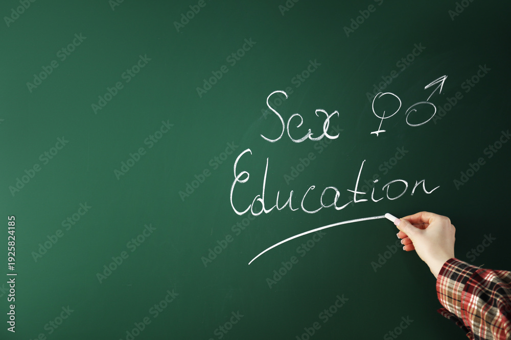 Fototapeta premium Woman writing words Sex Education on green chalkboard, closeup. Space for text