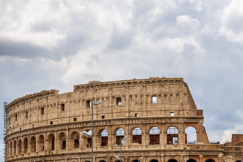 Obraz premium Famous tourist attraction of historic Colosseum amphitheatre with ancient stone arches in Rome Italy