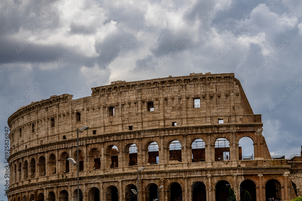 Obraz premium Famous tourist attraction of historic Colosseum amphitheatre with ancient stone arches in Rome Italy