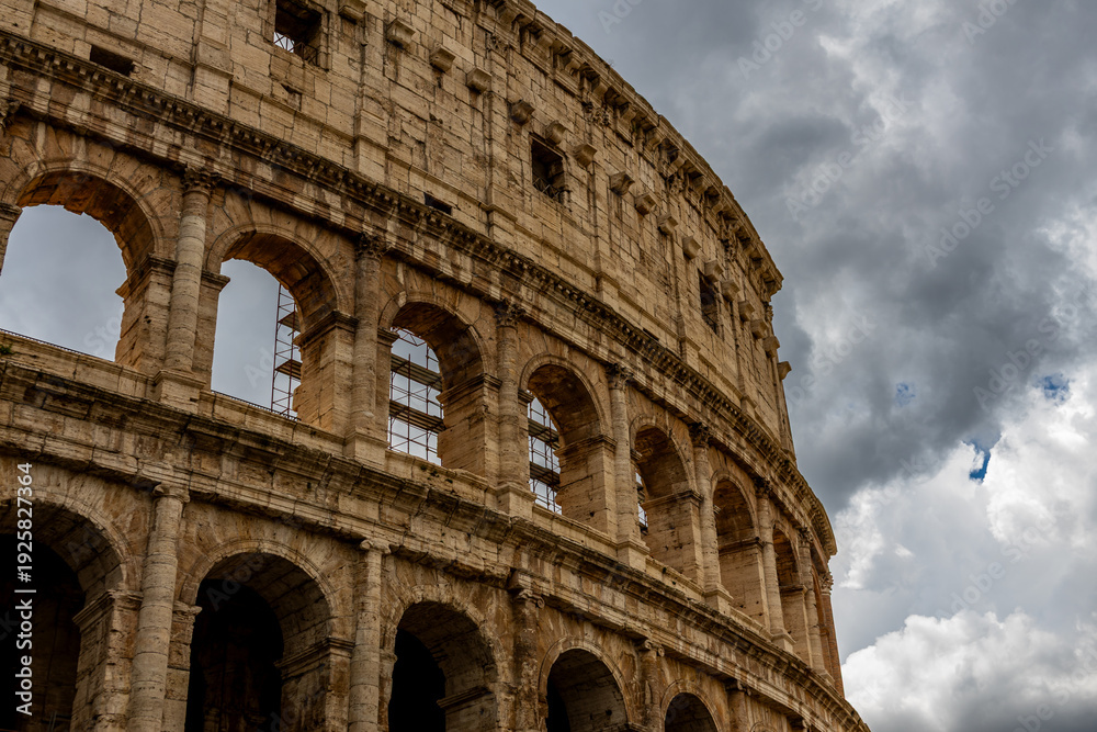 Fototapeta premium Famous tourist attraction of historic Colosseum amphitheatre with ancient stone arches in Rome Italy