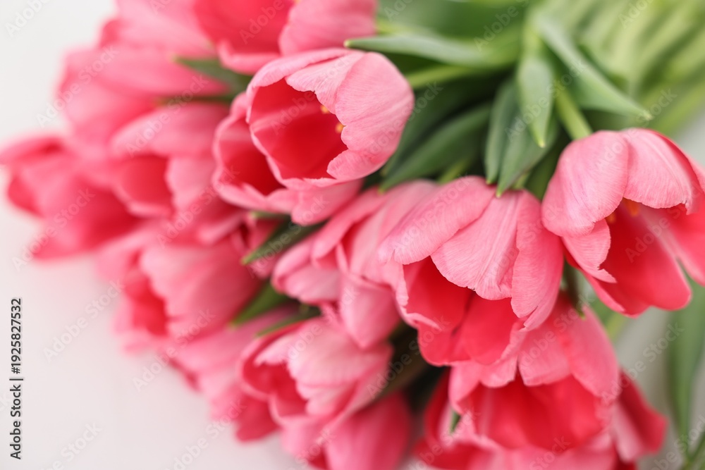 Fototapeta premium Bouquet of pink tulips on white table, closeup
