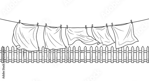 Clean laundry drying on a clothesline fluttering in the breeze against a wooden fence symbolizing freshness domesticity