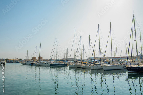 Sailing yachts moored in marina under clear blue sky