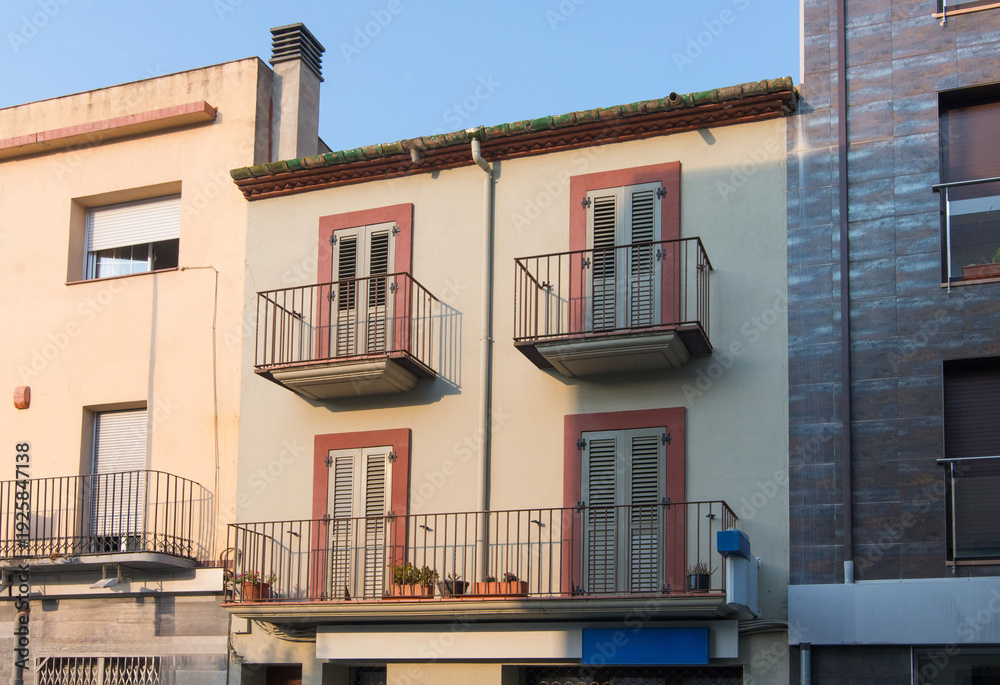 Obraz premium European house facade with metal balconies and window shutters