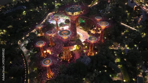 Singapore by Night – 4K aerial drone footage of marina bay sands, city skyline, skyscrapers, luxury hotels, gardens by the bay, garden Rhapsody, dome and river illuminated in financial district (CBD).