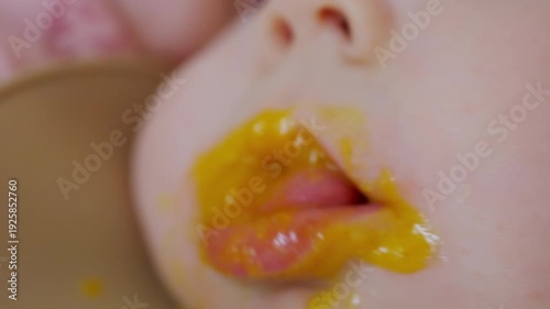 Wallpaper Mural Close up of a baby being fed with a spoon, showing facial details and soft expressions Torontodigital.ca