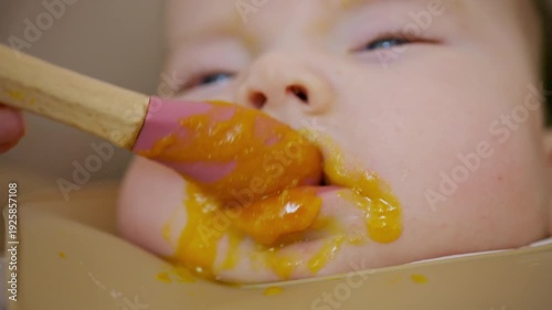 Wallpaper Mural Close up of a baby being fed with a spoon, showing facial details and soft expressions Torontodigital.ca