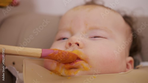 Wallpaper Mural Close up of a baby being fed with a spoon, showing facial details and soft expressions Torontodigital.ca