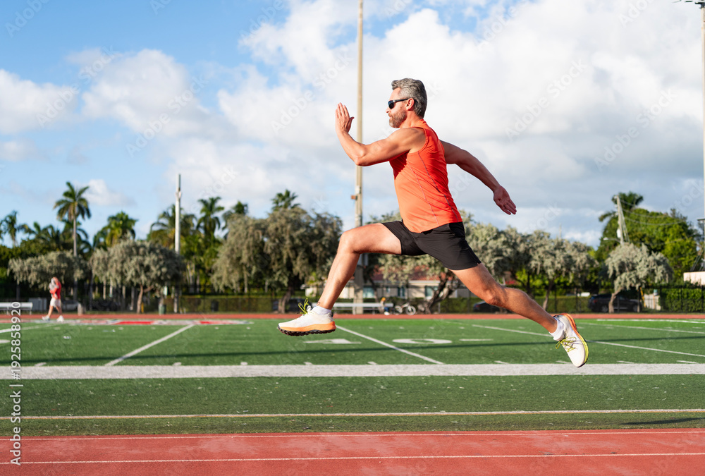 Naklejka premium Sportsman runner running outdoor. Sport run. Muscular man running. Sportsman jogger running. Man sportsman running to exercise. Sport athlete man run. Runner at long sport run