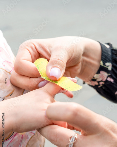 Child first aid. Toddler finger treated by parent hands. Home healthcare concept.