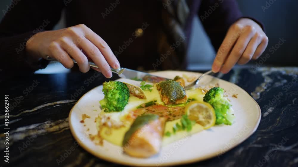 custom made wallpaper toronto digitalClose up of hands using knife and fork to cut a salmon fillet served with broccoli and sauce