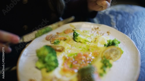 Wallpaper Mural Close up of hands using knife and fork to cut a salmon fillet served with broccoli and sauce Torontodigital.ca