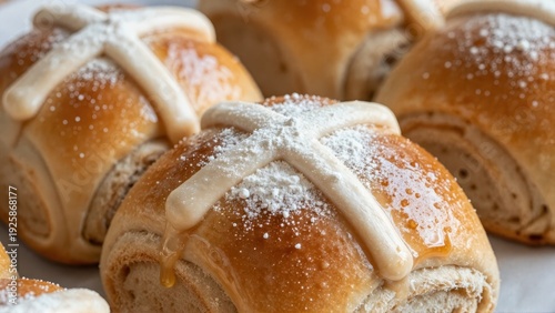 Extreme closeup of thick, sticky sugar glaze and precise white flour cross on freshly baked hot cross bun, emphasizing crumb texture and warmth.