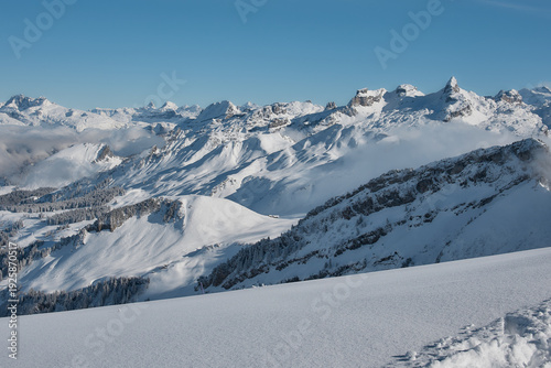 Snowy alpine peaks under clear blue sky, Stoos Switzerland