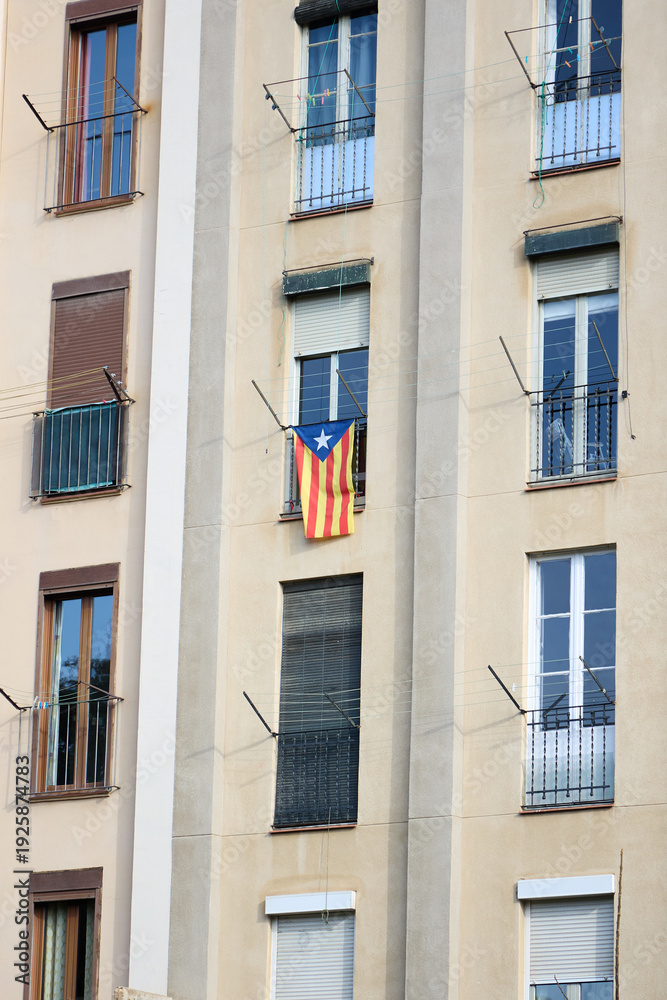 Obraz premium Fachada de edificio residencial en Barcelona con bandera independentista catalana en el balcón 