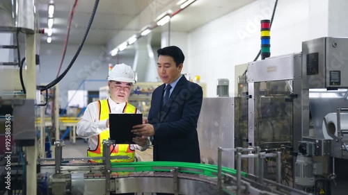 Asian factory manager and quality control inspector reviewing production process line in food manufacturing plant with safety hygiene and industrial packaging operation in modern processing facility