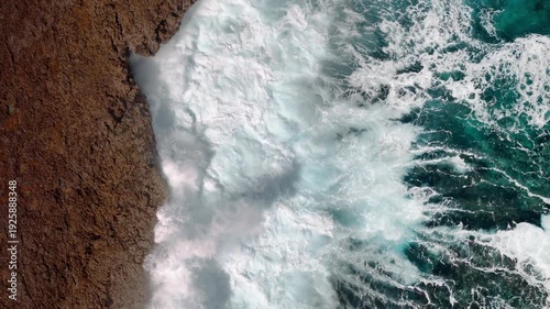 Toma cenital aérea de drone, de las olas rompiendo sobre las rocas / vista aérea de la textura del mar 