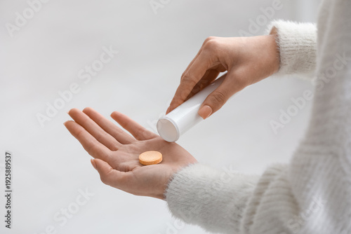 Young woman taking vitamin ...