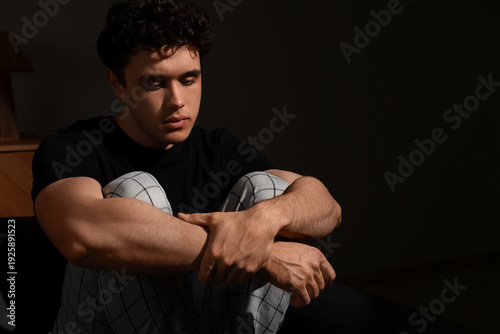 Upset young man sitting on ...