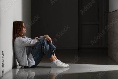 Sad young woman sitting on ...