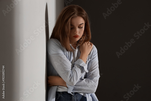 Sad young woman in dark roo...