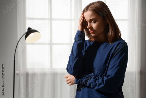 Sad young woman at home. In...