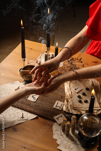 Tableau sur toile Fortune teller reading woman's palm at table
