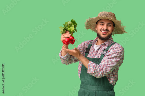 Male farmer with ripe radish on green background