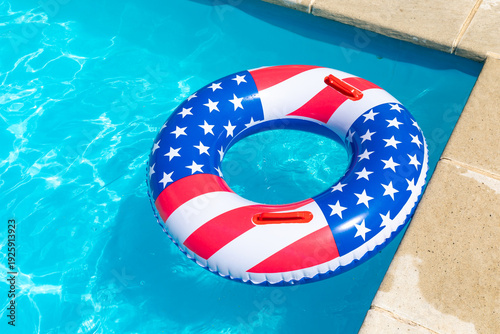 American Flag pool float. Top view of ring circle on blue water background. Summer vacation concept. Vacation in USA concept. 4th of July pool party. High quality photo
