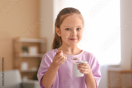Cute little girl eating yog...