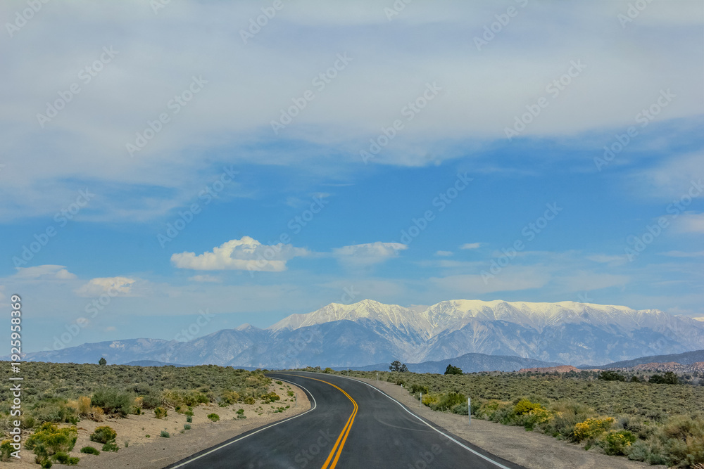 Fototapeta premium A long road with a mountain range in the background