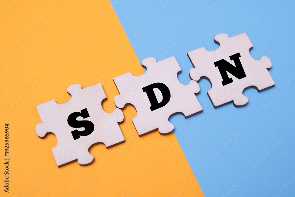 Obraz premium SDN word alphabet letters on wooden puzzle. SDN acronym for Software Defined Networking