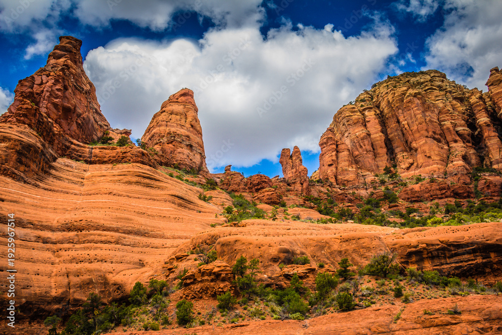 Fototapeta premium A rocky mountain range with a few trees and a blue sky