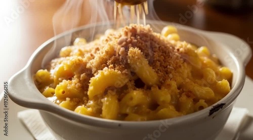 A steaming bowl of creamy macaroni and cheese, with a crispy, golden-brown breadcrumb topping, in a vintage ceramic bowl