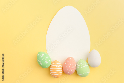 Conceptual Easter card with Easter eggs on a yellow background