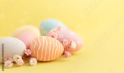 painted Easter eggs and flowers on a yellow background