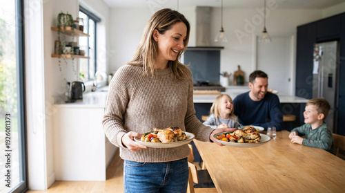  Middle-aged mother serving food on dining table