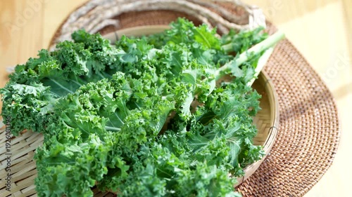 Fresh green kale leaves in woven basket, organic leafy vegetable for healthy eating, vegan diet and clean nutrition concept, natural farm produce close up video