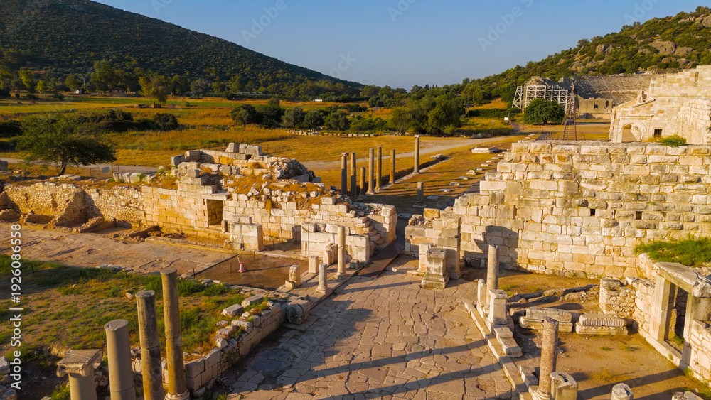 Obraz premium Gelemis, Turkey. Aerial flight from Colonnaded Street over city wall to panorama of Patara ancient city with theatre, parliament, beach and lighthouse. Aerial View