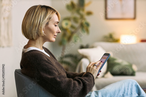 Photos Caucasian middle aged woman sitting indoors using phone for health tracking or f