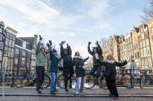 Photos Group of excited mature women friends jumping on a canal bridge in amsterdam, ce