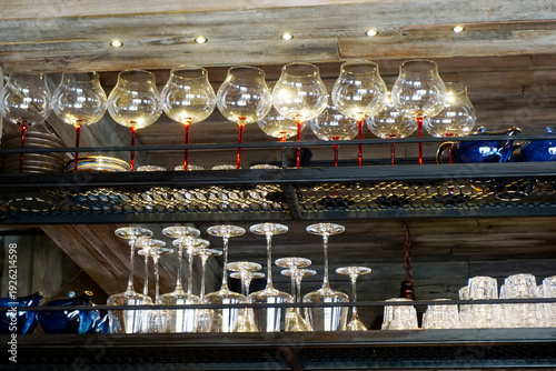 Group of wine glass on shelf with lighting at bar