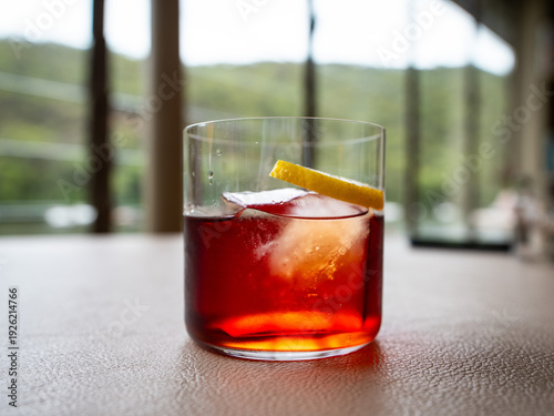 Elegant Red Cocktail with Large Ice Cube and Lemon Twist