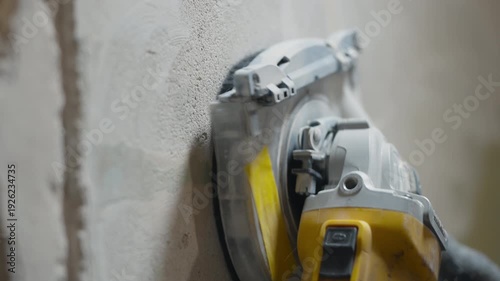 Construction worker grinding a concrete wall